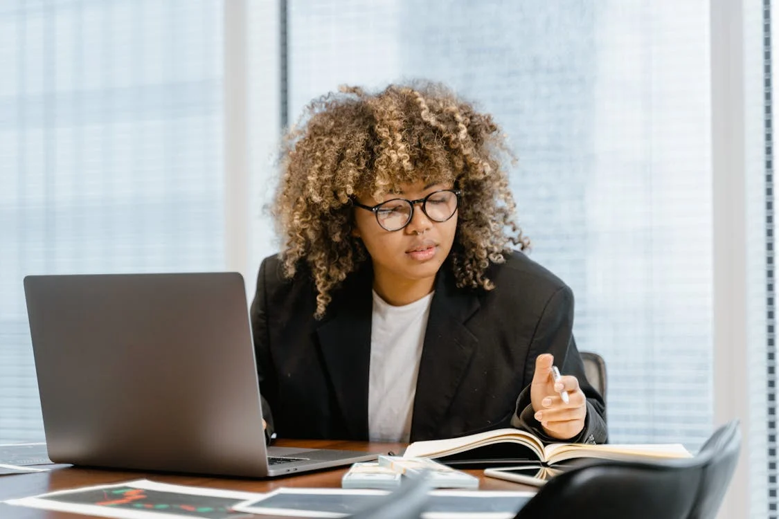 Liderança com expressão segura, em um ambiente de trabalho moderno e colaborativo.