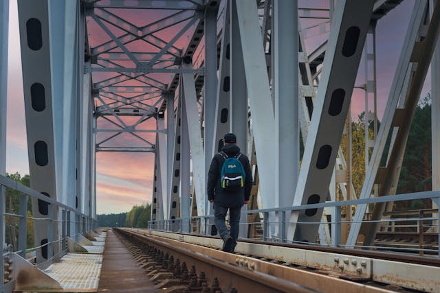 Pessoa atravessando ponte em direção a um novo destino profissional, simbolizando transição de carreira com planejamento.